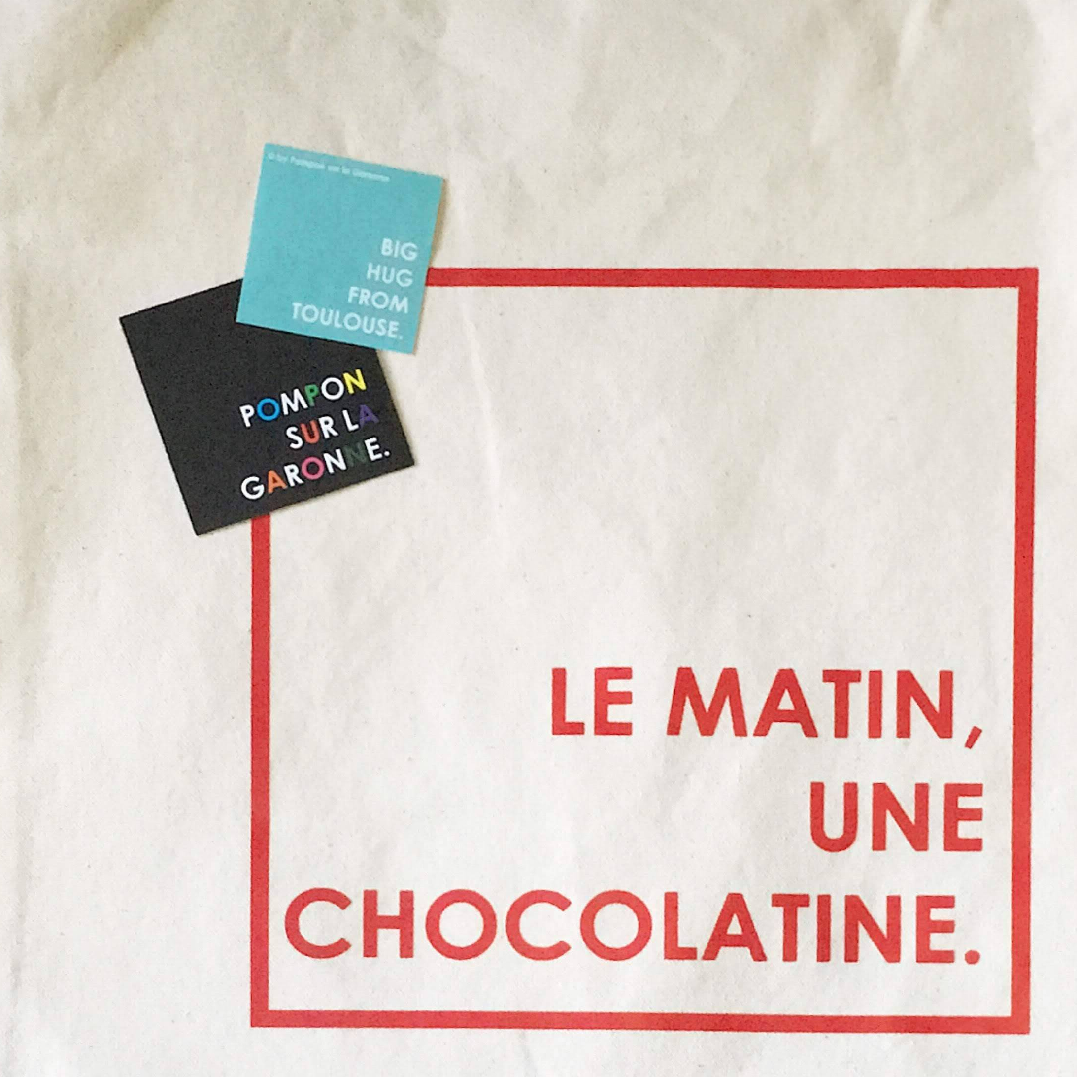 canvas tote back with French words Le Matin, une chocolatine which means a chocolate croissant every morning
