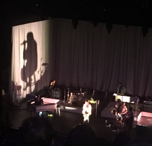 silhouette of woman singing on stage