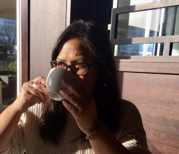 woman drinking coffee from white cup