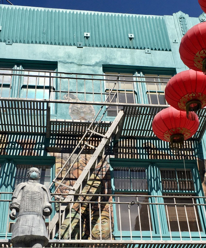 Red lanterns and statue wearing face mask