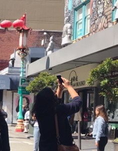 Woman taking photograph of statue with her phone
