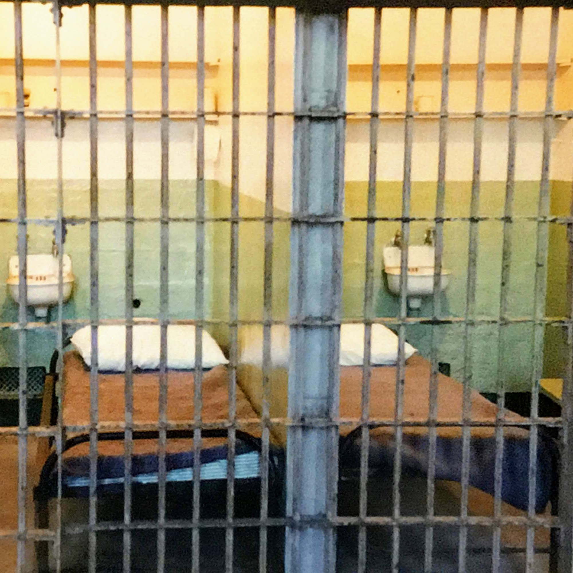 jail cells with bars, beds, and sinks