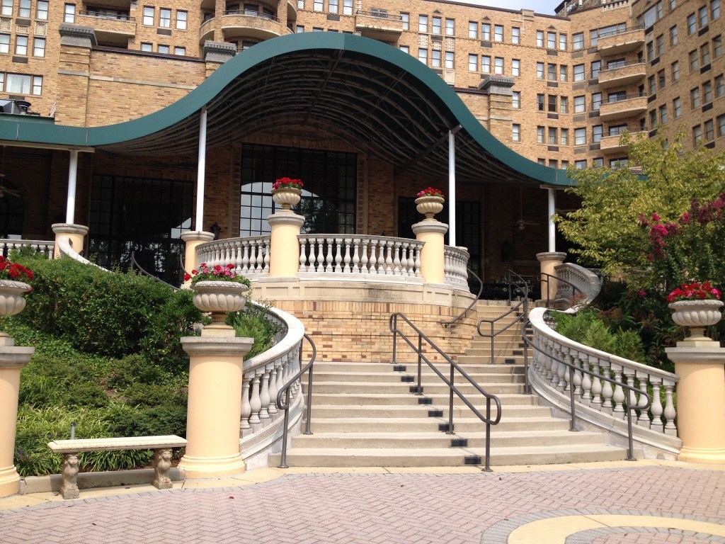 staircase with curvy green awning with hotel room windows in the background 