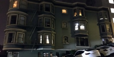 light blue house with three floors and twelve windows