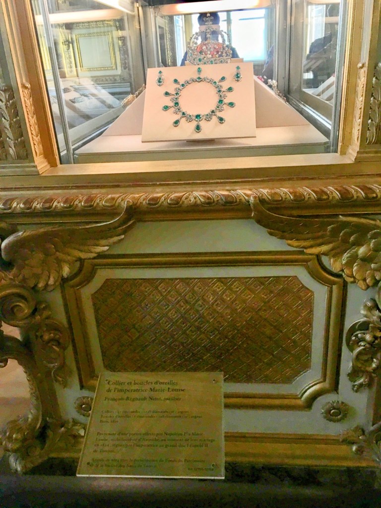 emeralds and diamonds necklace in glass case